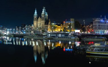 Aziz Niklas Bazilikası 'nın bir resmi, Amsterdam' da, geceleri birçok tur teknesine bakan..
