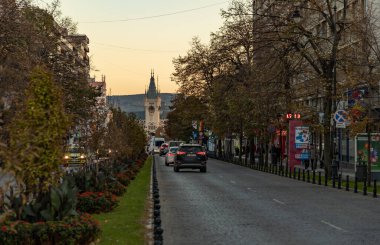 A picture of the Boulevard Stefan cel Mare si Sfant leading up to the Palace of Culture of Iasi at sunset and in the fall. clipart