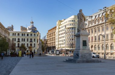A picture of the University Square in Bucharest, with the Statue of Gheorghe Lazar on the right and the Statue of Spiru Haret on the left.