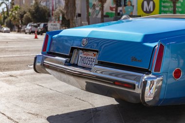 A picture of the rear side of a light blue Cadillac Eldorado.