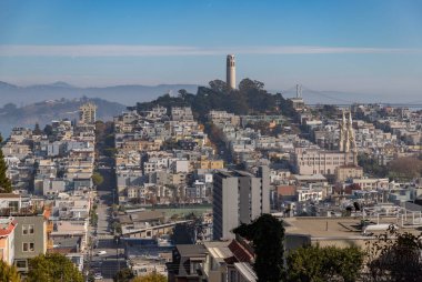 Coit Kulesi 'nin, Telegraph Hill, North Beach ve San Francisco' nun Rus Tepesi bölgelerinin tepesindeki resmi. Aziz Peter ve Paul Kilisesi de sağda oturuyor..