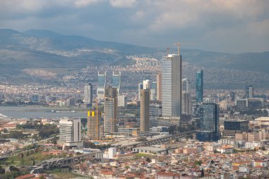 Bulutlu bir günde İzmir Bayrakli İlçesi 'nin resmi.