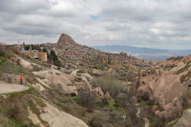 Uchisar kasabası ve Güvercin Vadisi 'nin bulutlu bir günde çekilmiş bir fotoğrafı..