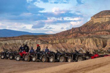 Goreme Tarihi Ulusal Parkı 'nın Kızıl Vadisi' nde gün batımında ATV turlarının bir resmi..
