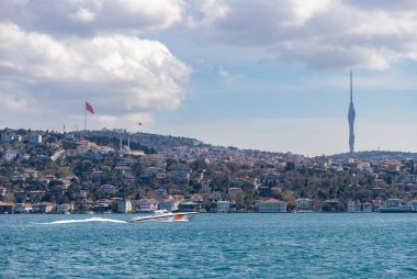 Boğazdaki sürat teknesine bakan Camlica Kulesi 'nin resmi..