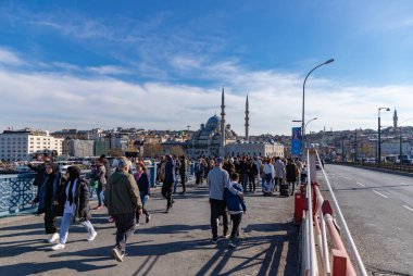 Galata Köprüsü ve Yeni Cami 'de yürüyen insanların resmi..