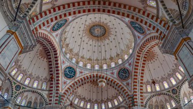 İstanbul 'daki Fatih Camii' nin renkli ve görkemli iç mekanının bir resmi.