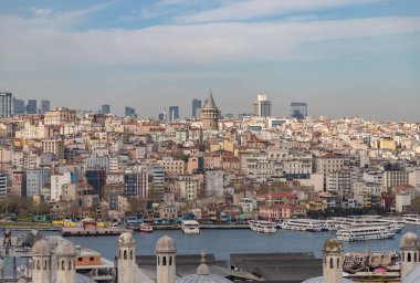 Beyoğlu bölgesinin binalarının ve rıhtımının tam ortasında Galata Kulesi olan bir resmi..