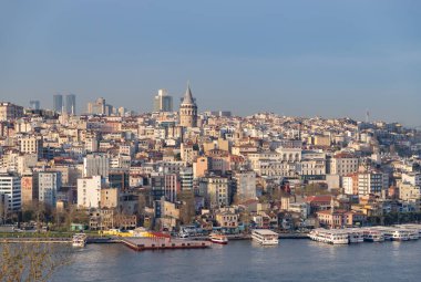 Beyoğlu bölgesinin solunda Galata Kulesi bulunan binaların ve limanın bir resmi..