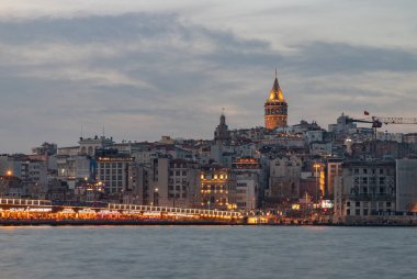Bulutlu bir günbatımında Beyoğlu bölgesi, Galata Kulesi ve Galata Köprüsü 'nün bir resmi..