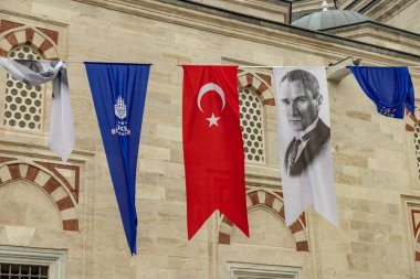 Bir caminin yanında İstanbul, Türk ve Atatürk afişlerinin resmi.