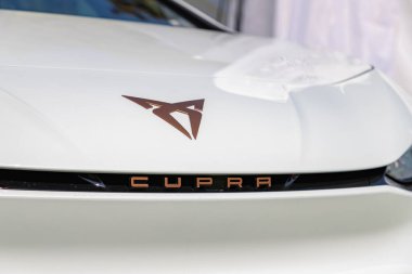 Beyaz bir arabanın üzerindeki Cupra logosunun resmi..