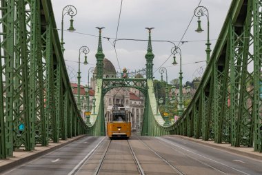 Liberty Köprüsü 'nün resmi ve Budapeşte' den geçen sarı bir tramvay..