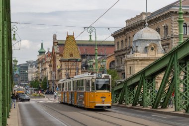 Liberty Köprüsü 'nün resmi ve Budapeşte' den geçen sarı bir tramvay..