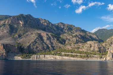 Domata Sahili kayalıklarının, çevreleyen manzaranın ve sahil manzarasının bir resmi..