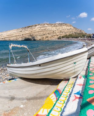 Matala Sahili 'nde beyaz bir teknenin resmi..