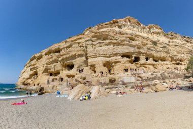 Matala Sahili 'nin tepesinde Matala Mağaraları olan bir resmi..