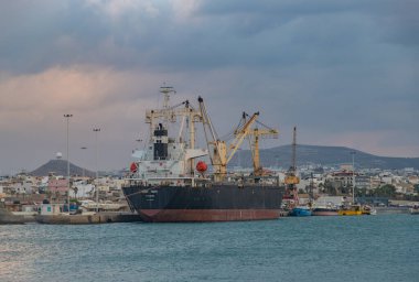 Gün batımında Heraklion Limanı 'ndaki Sunny Faith kargo gemisinin resmi..