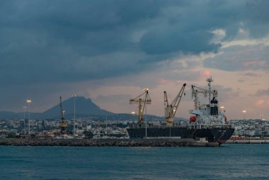 Gün batımında Heraklion Limanı 'ndaki Sunny Faith kargo gemisinin resmi..