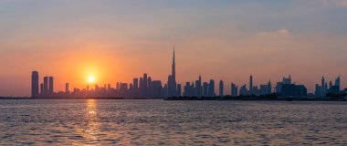 Gün batımında Dubai şehir merkezinin renkli bir manzarası ve Burç Halife 'nin tüm gökdelenlerde yükseldiği bir manzara..