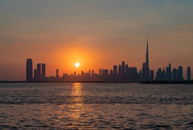 Gün batımında Dubai şehir merkezinin renkli bir resmi, Burj Halife diğer gökdelenlerde yükseliyor..