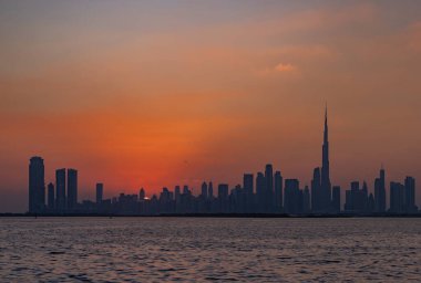 Gün batımında Dubai şehir merkezinin renkli bir resmi, Burj Halife diğer gökdelenlerde yükseliyor..