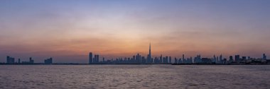 Gün batımında Dubai 'nin bir panorama resmi, Burj Halife' nin tüm gökdelenlerde yükseldiği.