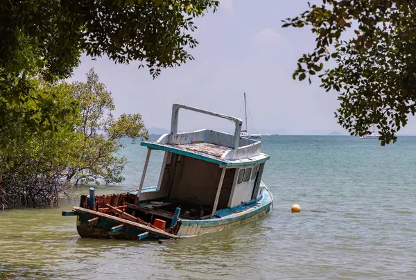 Railay Sahili 'nin doğusunda terk edilmiş bir teknenin resmi..