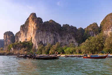 Batı Railay Plajı 'nın bir resmi, en uçta birden fazla uzun kuyruklu tekne var..
