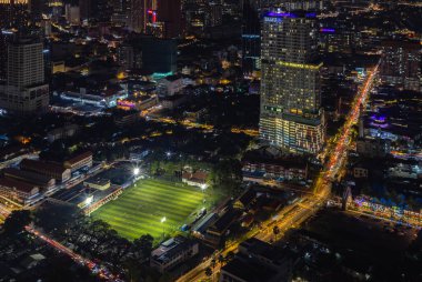 EV Arena Kelab Sultan Süleyman futbol sahasının ve Tamu Otel ve Suites Kuala Lumpur 'un geceleri çekilmiş bir resmi..