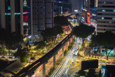 Kuala Lumpur 'un gece trafiğinin tek raylı ve yoğun bir kavşağı gösteren bir resmi..