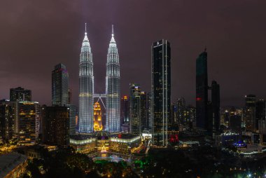 Petronas İkiz Kuleleri 'nin, KLCC Park' ın su ve fıskiye gösterisinin ve geceleri Suria KLCC alışveriş merkezinin resmi..