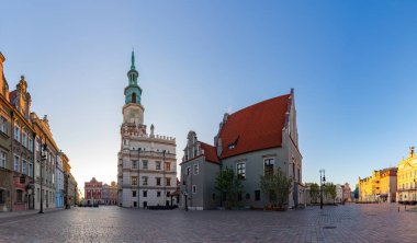 Poznan Eski Pazar Meydanı 'nın güneş doğarken çekilmiş bir resmi. Belediye binası ve ağırlık evi sergileniyor..