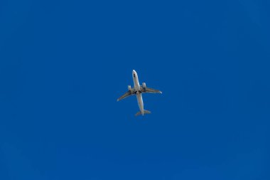 Mavi gökyüzünde uçan bir uçağın resmi..