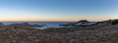 Lindos kasabasının ve gün batımında çevreleyen manzaranın panorama resmi..