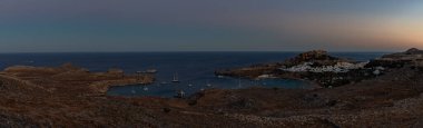 Lindos kasabasının ve gün batımında çevreleyen manzaranın panorama resmi..