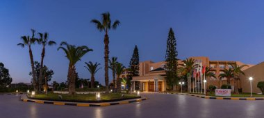 Günbatımında Wyndham Tunis 'in yanındaki Ramada Plaza' nın giriş alanının resmi..