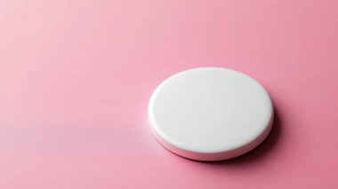 Yumuşak pembe arka planda minimalist beyaz bir tabak, şık bir sunum için mükemmel..