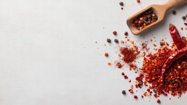 Tam bir kara biber ve beyaz arka planda ezilmiş kırmızı biber.