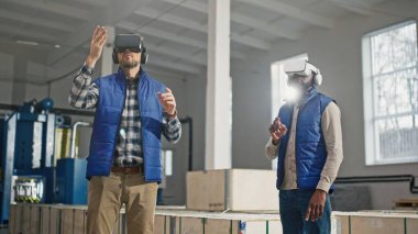 Üretimde olası gelişmeler için Sanal Gerçeklik kulaklığı kullanan çok ırklı iş arkadaşları. Modern işlerde insanlara yardım eden dijital bir cihaz. Yeni bir kavram öğrenmek için VR kullanırken el sıkışmak.