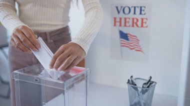 Beyaz kadın, ABD 'nin bir sonraki başkanına oyunu plastik sandığa koyuyor. Amerika 'da seçim. İnsanlar liderlerini seçiyor ve vatandaşlık görevlerini tamamlıyorlar. Yöneten insanları imzala.