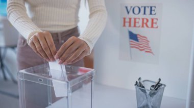 Beyaz kadın, ABD 'nin bir sonraki başkanına oyunu plastik sandığa koyuyor. Amerika 'da seçim. İnsanlar liderlerini seçiyor ve vatandaşlık görevlerini tamamlıyorlar. Yöneten insanları imzala.