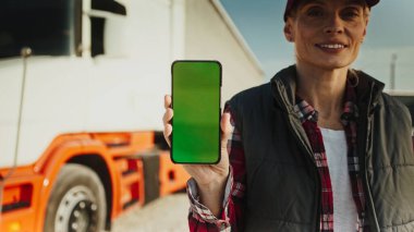 Kamyon sürücüsü elinde boş ekranın akıllı telefon maketini tutuyor.