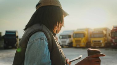 İnsanların e-ticaret ve perakende lojistik sektöründe çalışırken konuştuklarını yan görüyorum. Bir elinde koğuş içkisi tutan bir kadın. Adam kamyon hakkında önemli sorular soruyor. Güvenlik denetimi.