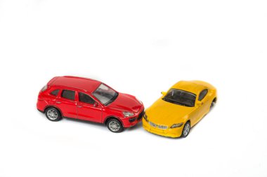 Beyaz arka planda oyuncak araba kazası. Sigorta konsepti.