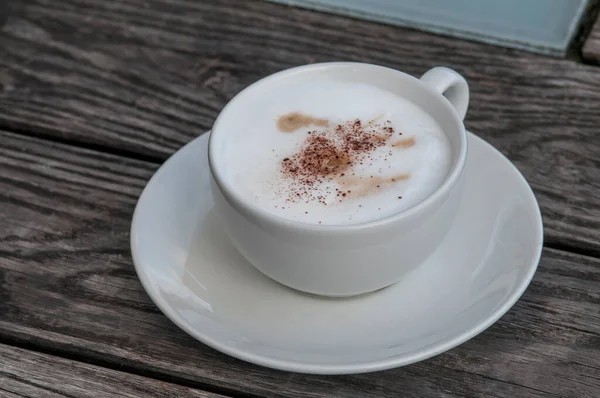 Ahşap Masa Arkasında Köpüklü Bir Fincan Kahve — Stok fotoğraf