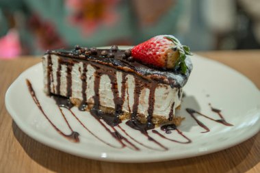 Kafedeki bir tabakta çilekli kekin yakın çekimi.