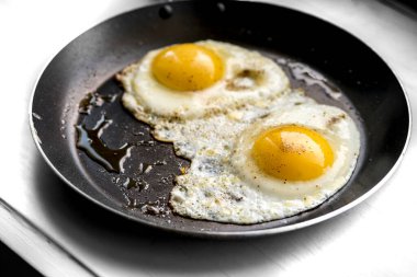 Siyah tavada yakın plan yumurta.