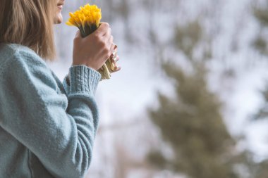 Bir buket sarı çiçeği tutan kadın
