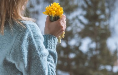 Bir buket sarı çiçeği tutan kadın